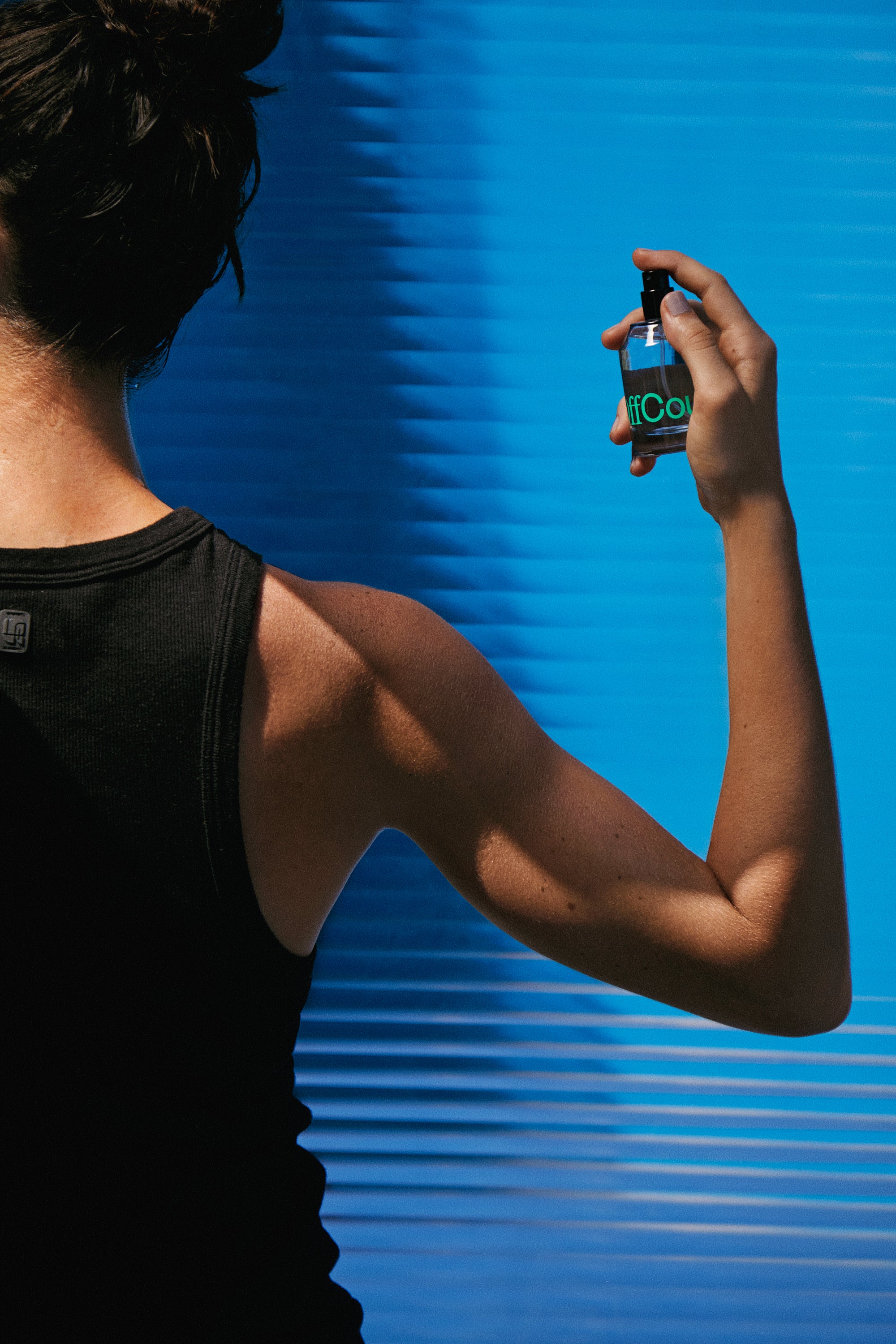 A woman spraying fragrance 