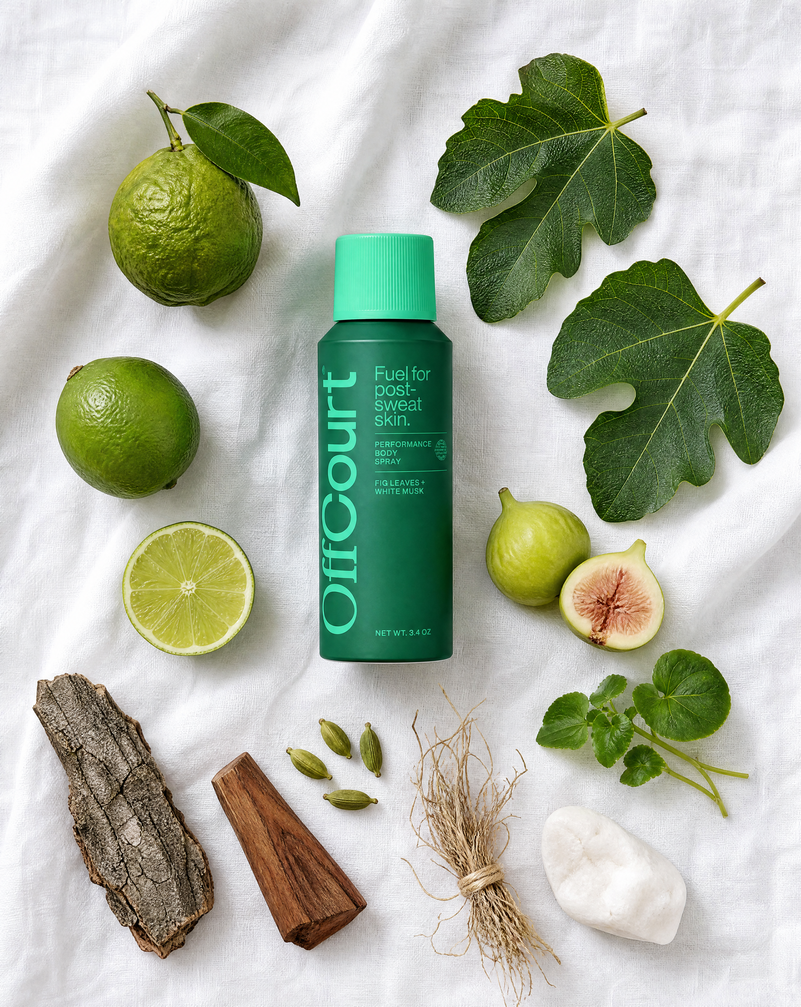 Fig Leaves + White Musk body spray on linen, surrounded by limes, fig leaves, figs, cardamom, vetiver, wood, bark, and white stone