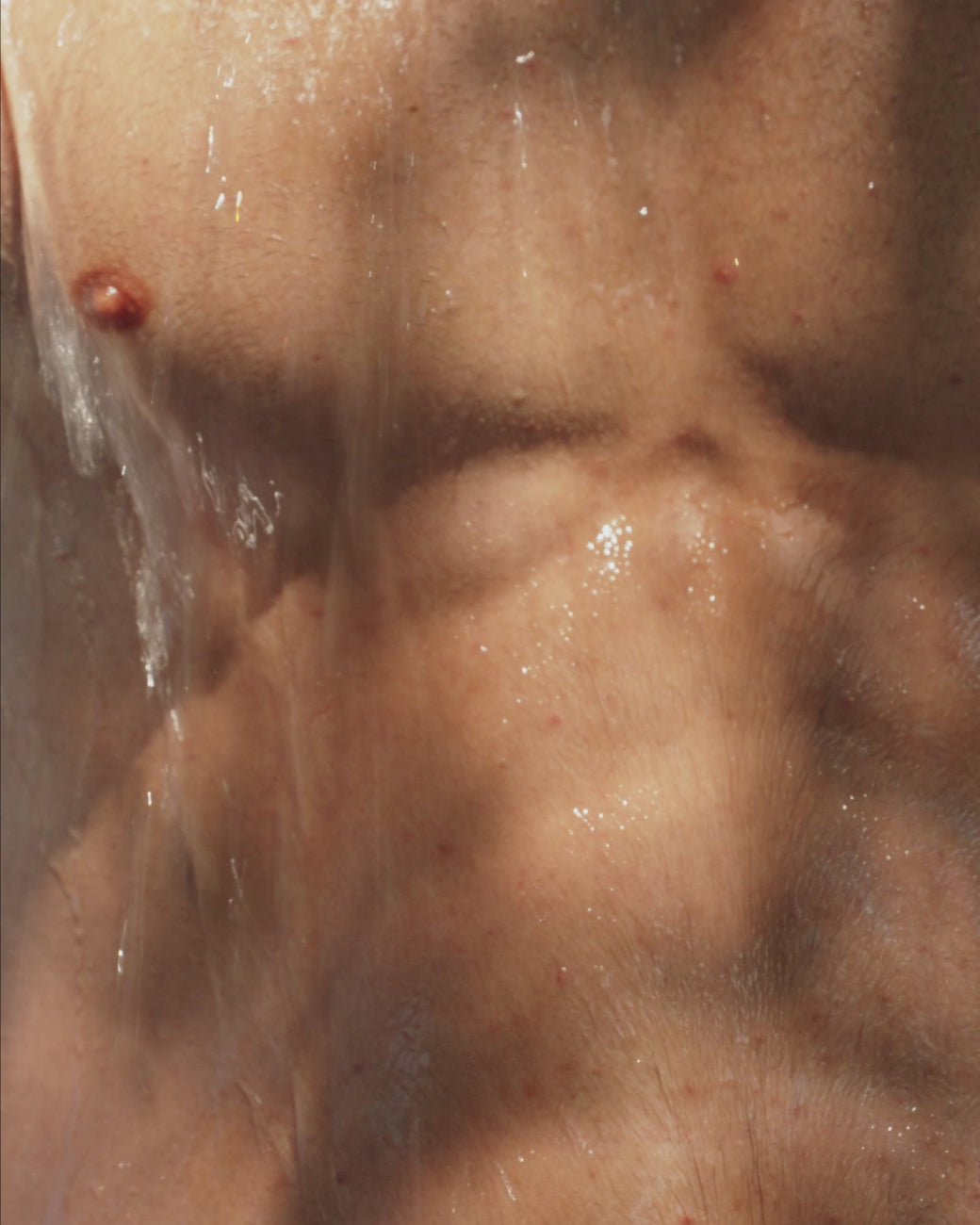 a model washing his body with a soap
